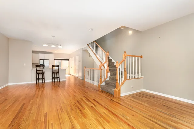 a view of a livingroom with wooden floor and a chairs