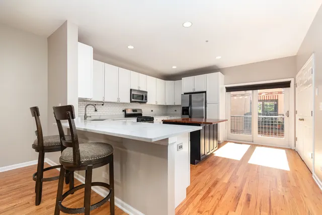 a kitchen with a table chairs refrigerator and cabinets