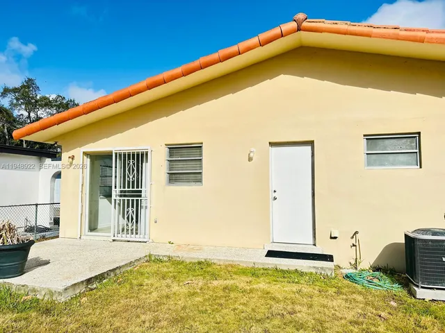 a blue white house with a large pool