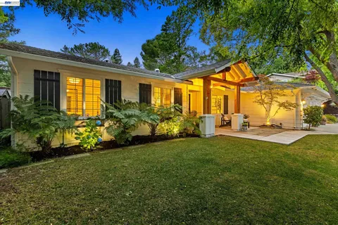 a view of a house with backyard sitting area and garden