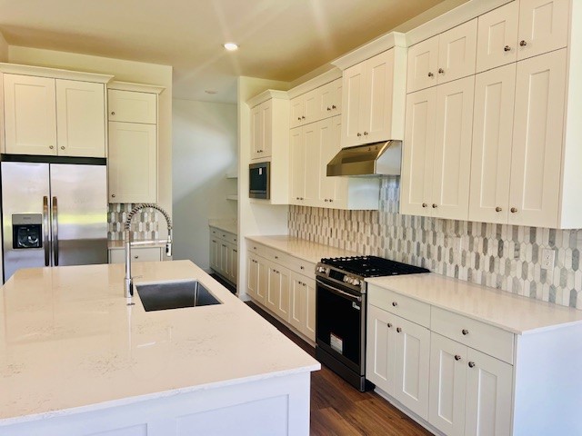 31535 Fern Grove Road Fulshear, TX 77423 - Photo 2 of 26 a kitchen with granite countertop white cabinets and stainless steel appliances