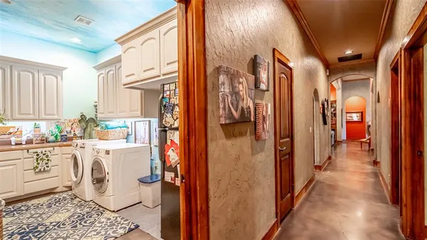 a storage room with stainless steel appliances a refrigerator and cabinets