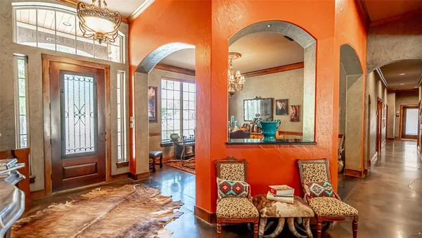 a living room with furniture a large window and wooden floor