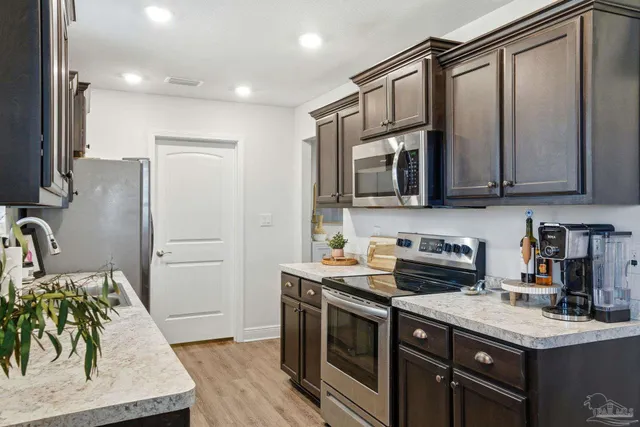 a kitchen with granite countertop a sink a counter space stainless steel appliances and cabinets