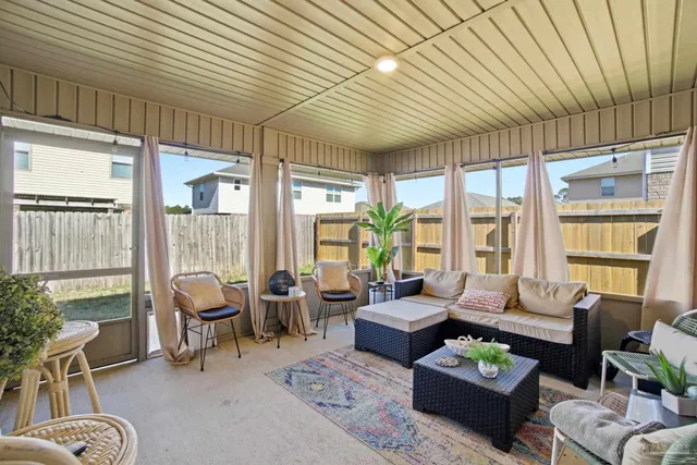 a living room with furniture a flat screen tv and a large window