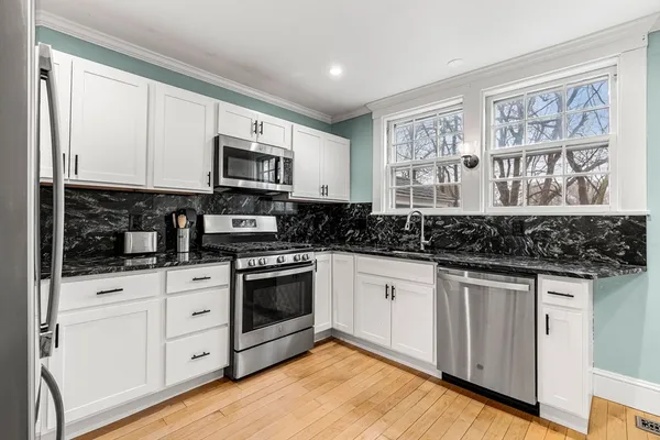 a kitchen with stainless steel appliances granite countertop a stove a sink and a microwave