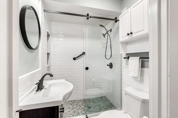 a bathroom with a sink a toilet and shower