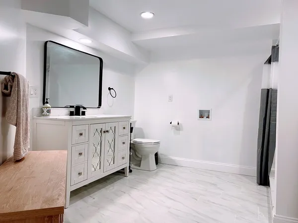 a bathroom with a toilet sink and mirror
