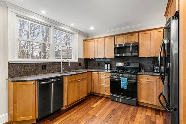a kitchen with stainless steel appliances granite countertop a stove a sink and a microwave