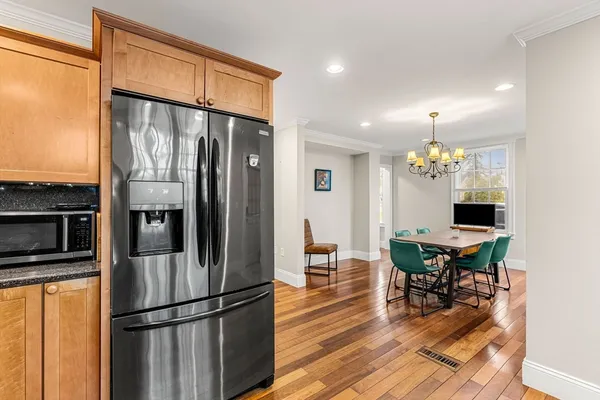 a kitchen with stainless steel appliances granite countertop a refrigerator dining table and chairs