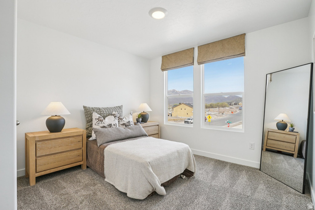 2097 North Ostler Peak Road, Unit 115 Heber City, UT 84032 - Photo 7 of 33 Bedroom featuring two large windows with roller shades, light gray carpeting, and white walls