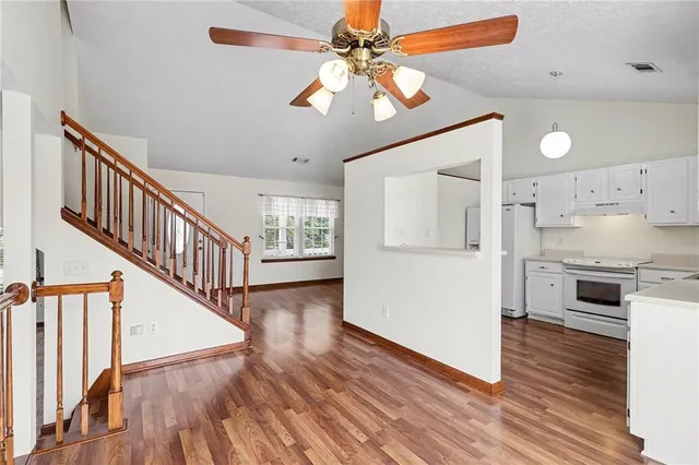 a kitchen with cabinets appliances a sink and dishwasher with wooden floor