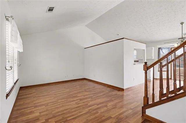 a view of empty room with fireplace and wooden floor