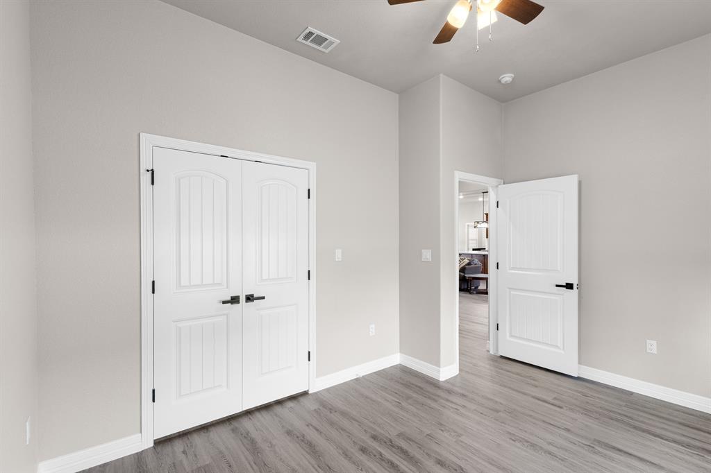 1404 Faulkner Road Sunset, TX 76270 - Photo 30 of 40 Unfurnished bedroom with light wood-type flooring, a ceiling fan, and a closet
