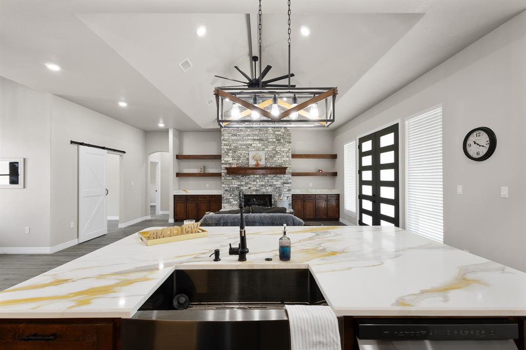 1404 Faulkner Road Sunset, TX 76270 - Photo 40 of 40 Kitchen with a barn door, open floor plan, a kitchen island with sink, light stone counters, and recessed lighting