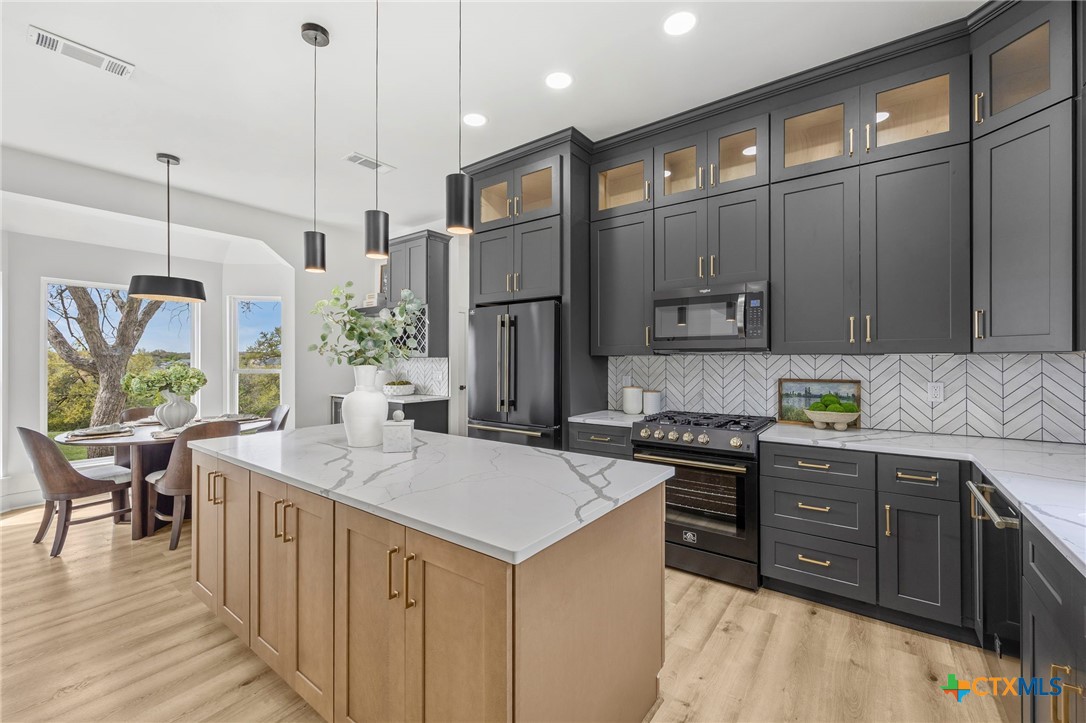 108 Skyline Road Georgetown, TX 78628 - Photo 13 of 48 a kitchen with stainless steel appliances granite countertop a sink a stove and a refrigerator