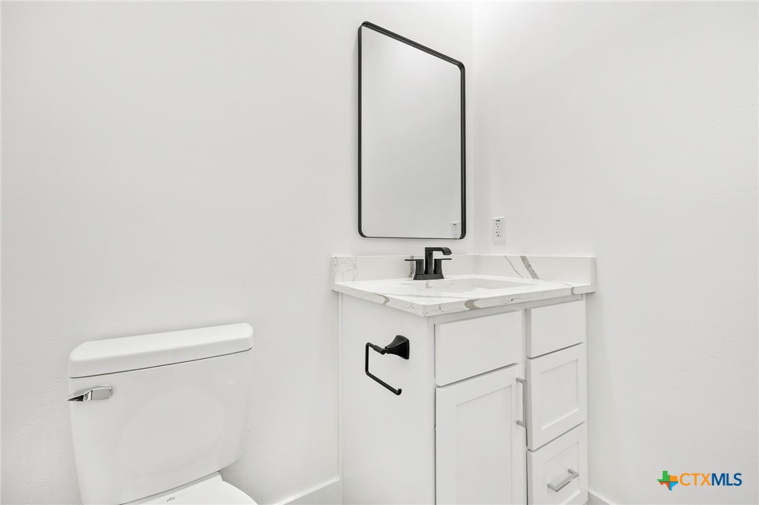 108 Skyline Road Georgetown, TX 78628 - Photo 37 of 48 a bathroom with a sink a toilet and mirror