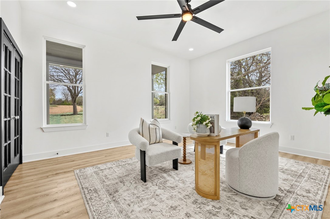 108 Skyline Road Georgetown, TX 78628 - Photo 7 of 48 a living room with couches and a potted plant on a table with wooden floor