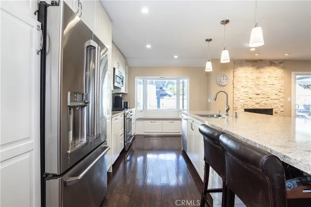a kitchen with stainless steel appliances granite countertop a sink a stove and a refrigerator