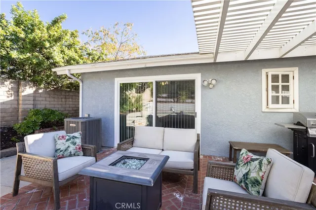 a living room with patio furniture and a potted plant