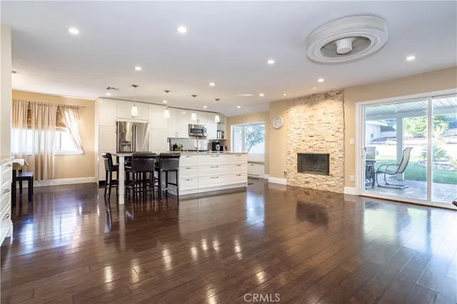 a kitchen with stainless steel appliances kitchen island granite countertop a table chairs sink and cabinets