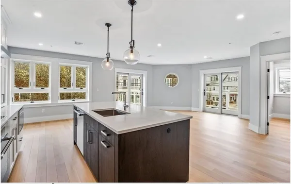 a kitchen with stainless steel appliances granite countertop a stove and a large window