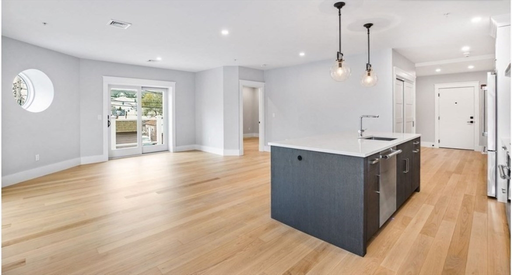 131 Front Street, Unit 1 Scituate, MA 02066 - Photo 5 of 15 a large kitchen with stainless steel appliances granite countertop a large counter top a sink and a refrigerator