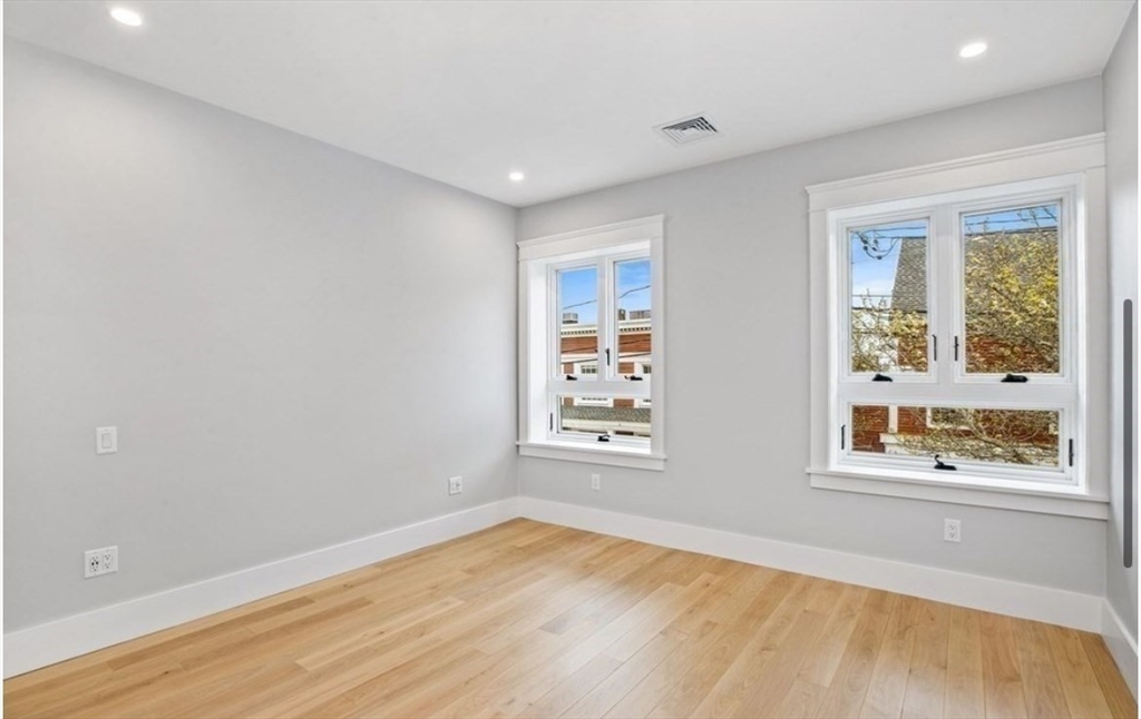 131 Front Street, Unit 1 Scituate, MA 02066 - Photo 8 of 15 a view of an empty room with wooden floor and a window