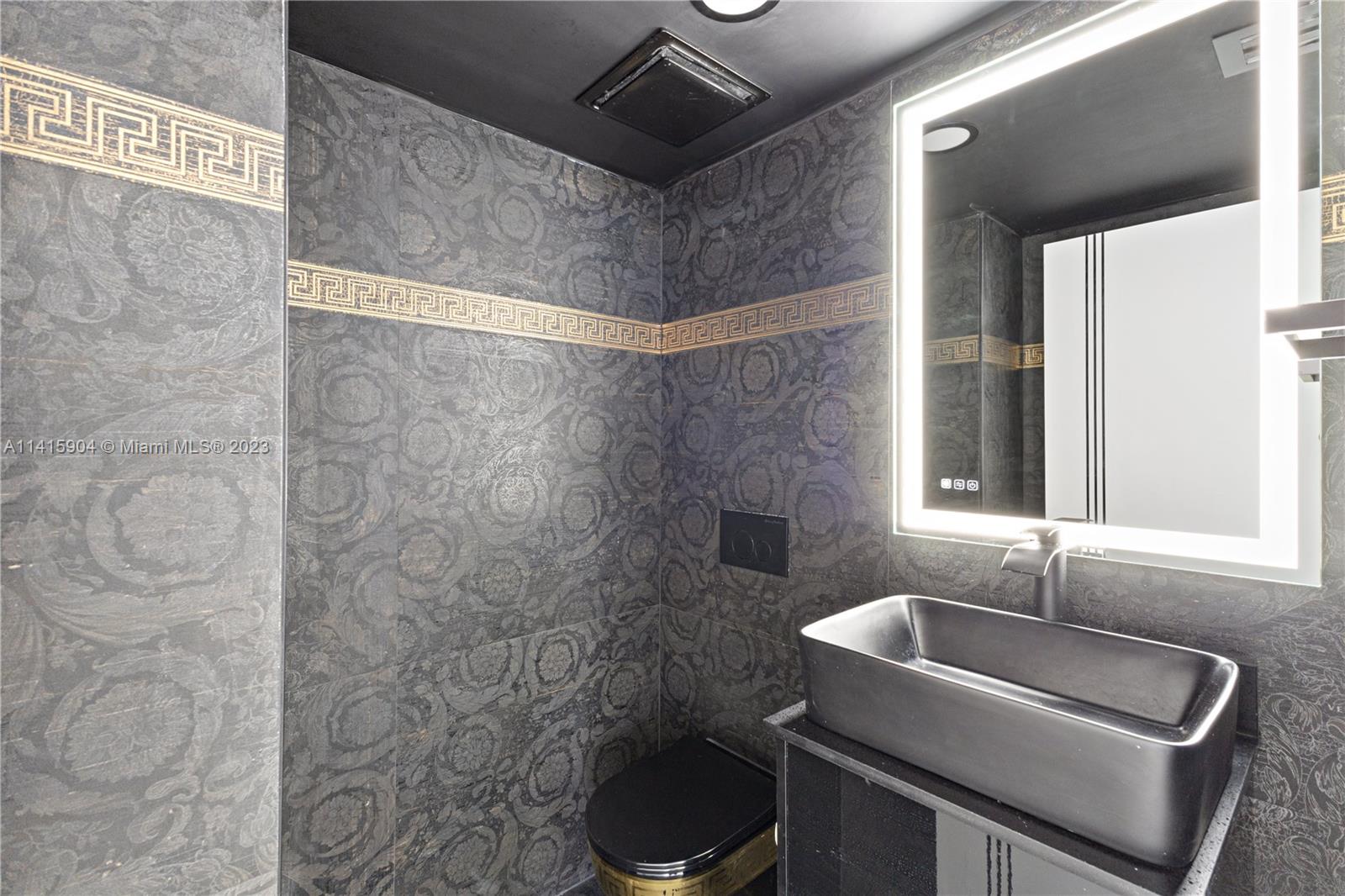 Miami Beach Miami Beach, FL 33139 - Photo 31 of 41 a bathroom with a granite countertop sink a toilet and bathtub