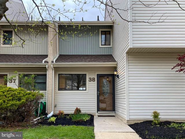 a view of a white house with a yard and plants
