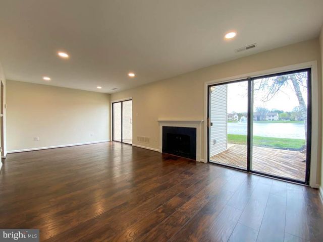 a view of empty room with wooden floor and fireplace