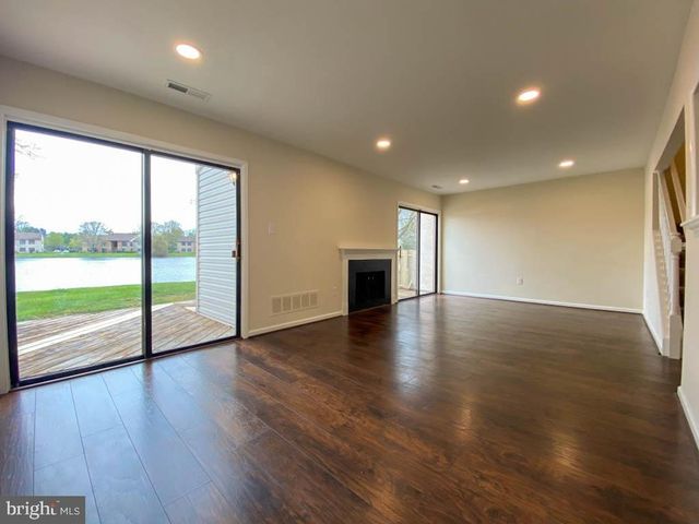 a view of empty room with wooden floor and fireplace