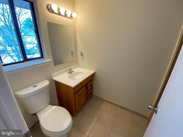 a bathroom with a toilet a sink a vanity and mirror