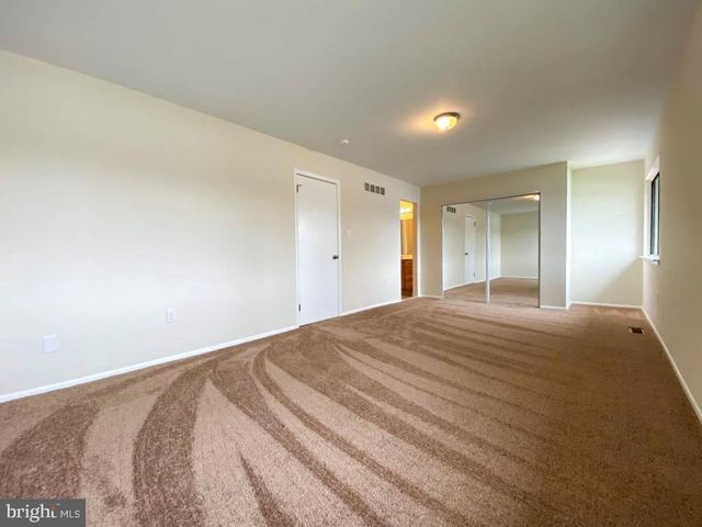 a white toilet sitting next to a bathroom sink and a mirror
