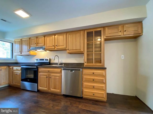 a kitchen with granite countertop wooden cabinets and white appliances