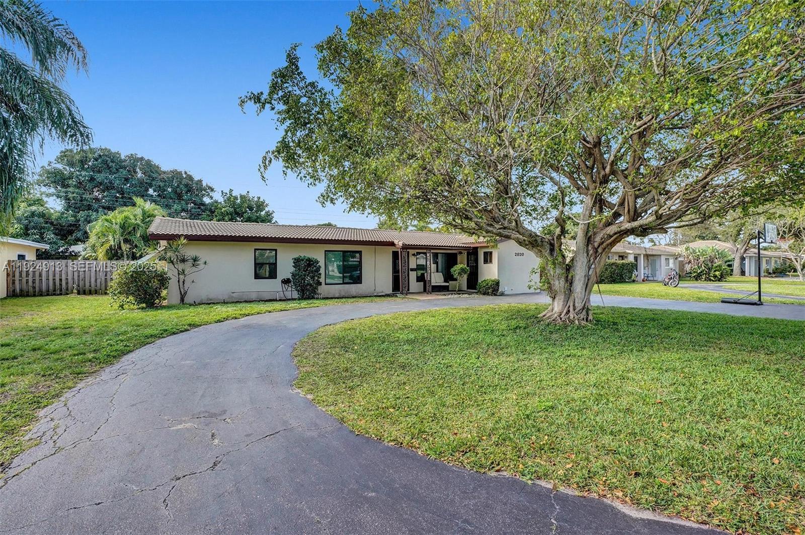2620 Northeast 19th Street Pompano Beach, FL 33062 - Photo 1 of 42 a front view of a house with a garden