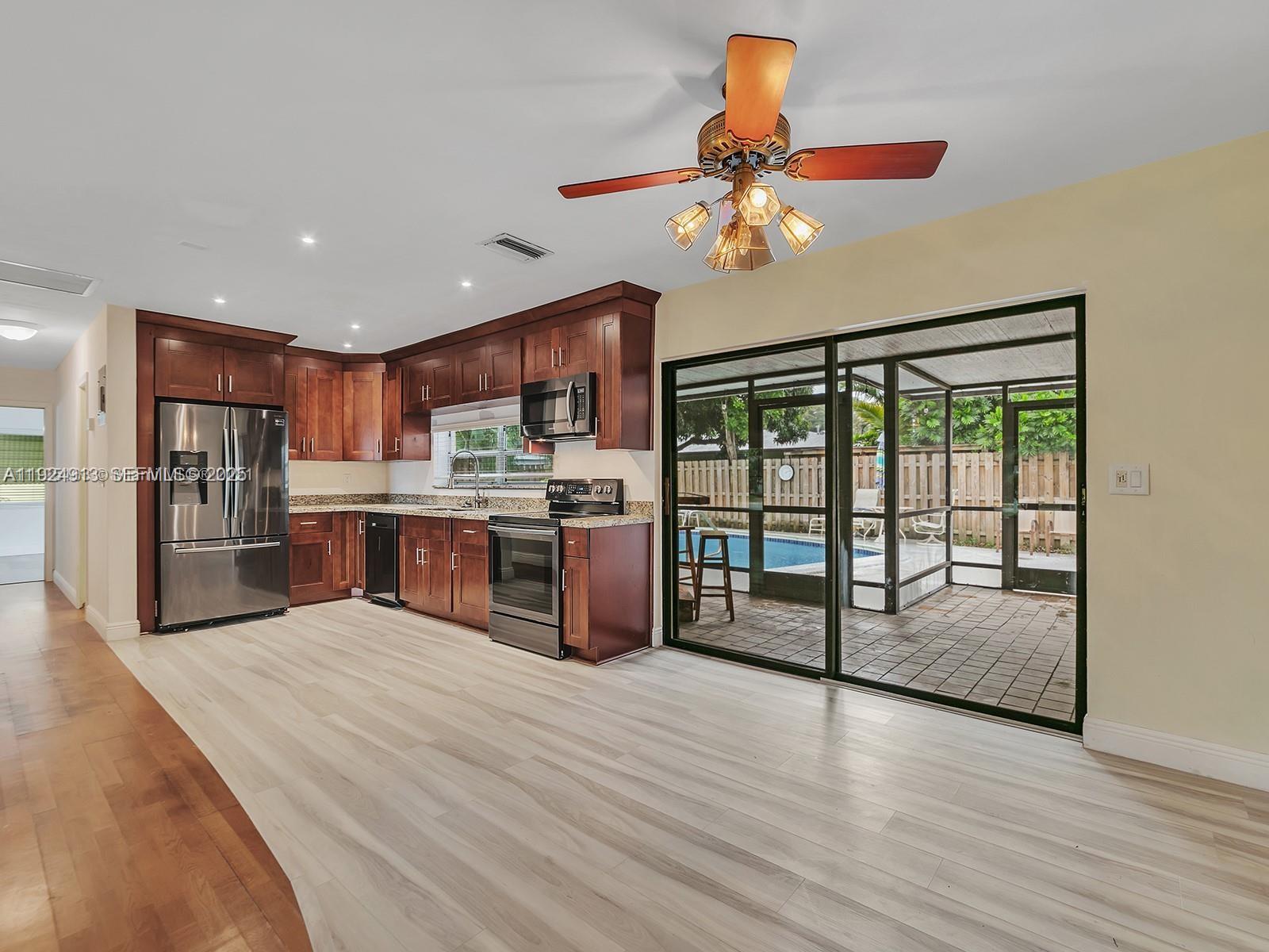 2620 Northeast 19th Street Pompano Beach, FL 33062 - Photo 14 of 42 a kitchen with stainless steel appliances granite countertop a refrigerator and a sink