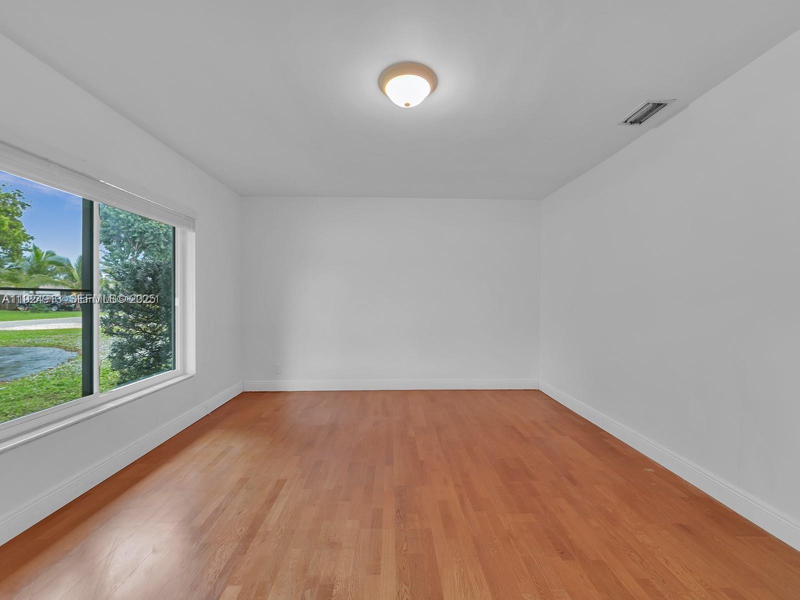 2620 Northeast 19th Street Pompano Beach, FL 33062 - Photo 24 of 42 a view of an empty room with a window and wooden floor