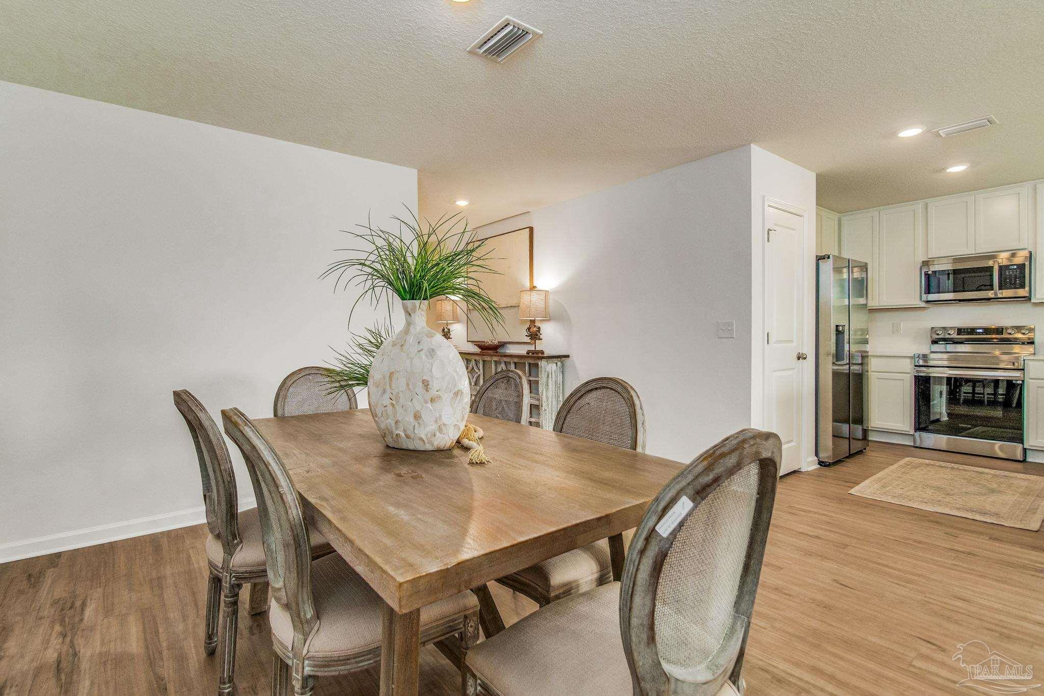 5454 Horizons Edge Lane Milton, FL 32583 - Photo 11 of 27 a dining room with furniture and wooden floor