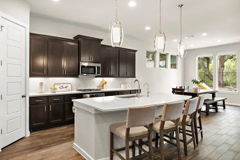 a kitchen with stainless steel appliances a stove a sink a microwave a center island and a refrigerator
