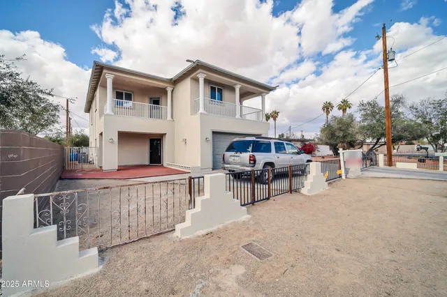 a view of a patio with couches and table and chairs with wooden fence
