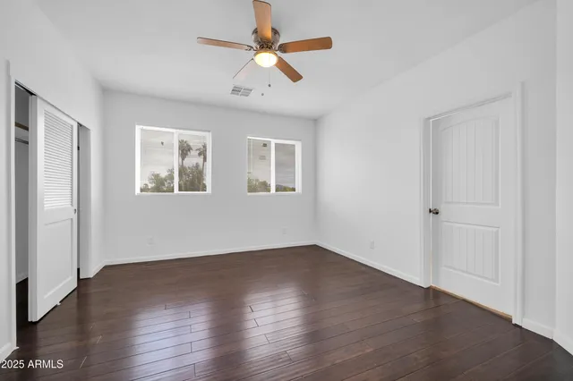 a bathroom with a granite countertop sink vanity mirror and toilet