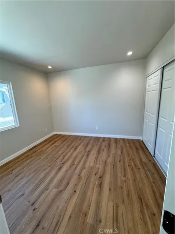 an empty room with wooden floor and entrance