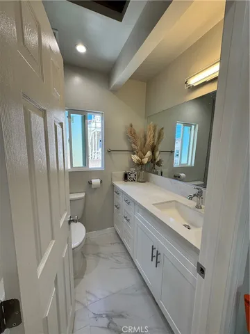 a spacious bathroom with a granite countertop sink toilet and shower