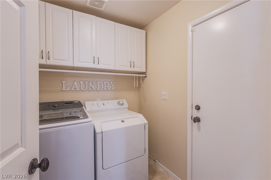 253 Camelback Ridge Avenue Henderson, NV 89012 - Photo 7 of 26 A functional dedicated workspace features overhead storage cabinets above the laundry appliances.