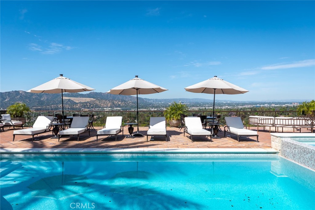 330 Kempton Road Glendale, CA 91202 - Photo 64 of 75 a view of a swimming pool with lawn chairs under an umbrella