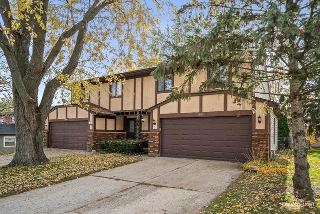a front view of a house with a tree