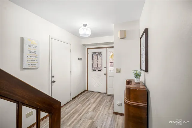 a view of a hallway with wooden floor and entryway