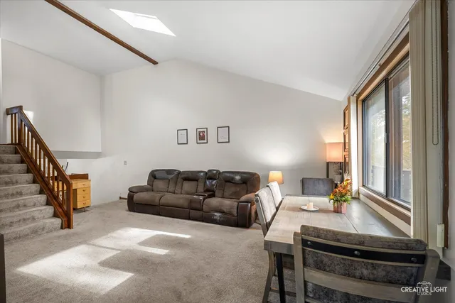 a living room with furniture a piano and a window