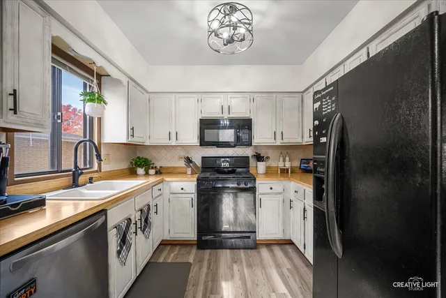 a kitchen with a sink stainless steel appliances cabinets and a counter top space